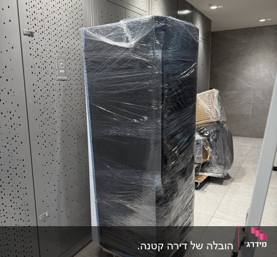 ארון עטוף בניילון על גלגלים בחדר מעבר
